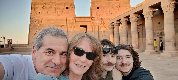 Famiglia che scatta un selfie davanti al pilone illuminato dal sole del Tempio di File, Assuan