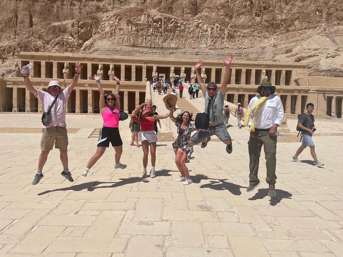 Viaggiatori felici che saltano davanti al Tempio di Hatshepsut a Luxor