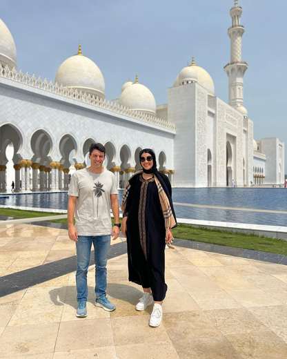 Coppia accanto alla vasca riflettente della Grande Moschea Sheikh Zayed, Abu Dhabi