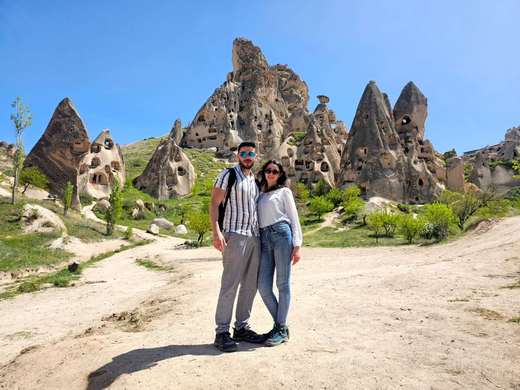 Coppia tra le abitazioni rupestri della valle di Uchisar, in Cappadocia, Turchia